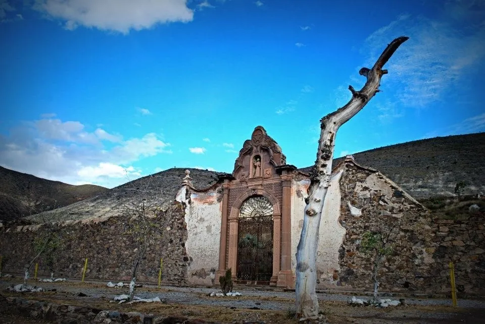 Old stone construction in Real de Catorce, San Luis Potosí, surrounded by mountains under a blue sky.